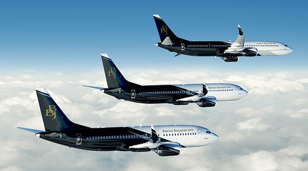 Boeing Business Jet formation above clouds
