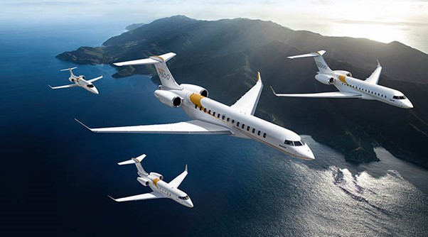 Formation of Bombardier jets in the sky over the ocean