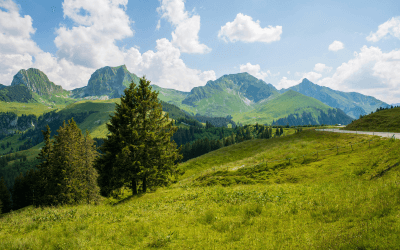 Scenic view of green grassy hill and mountain in the Swiss Alps; enhance your Verbier Festival experience with a 2025 private jet charter.
