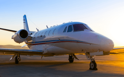 Private business jet silhouetted against a vibrant sunset at an African airport.